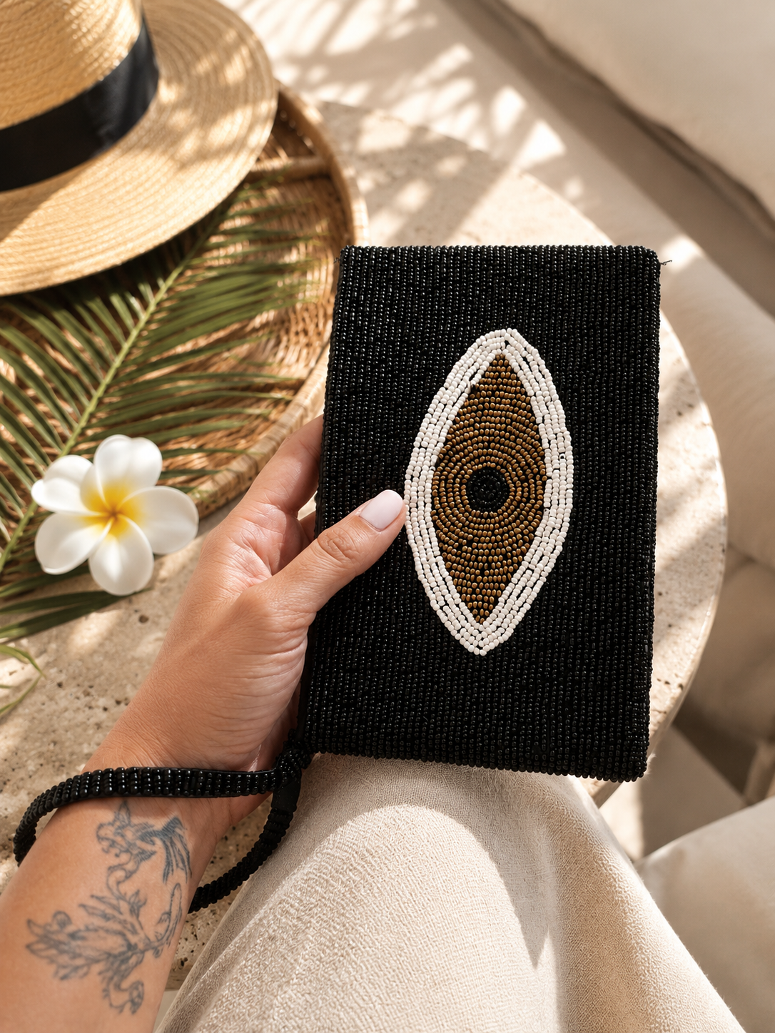 Noir Eye black hand-beaded clutch with ivory and bronze Evil Eye motif