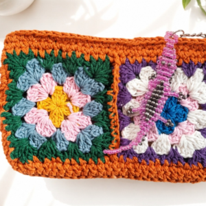 Solara handmade orange crochet clutch with colourful floral granny squares and pink beaded gecko