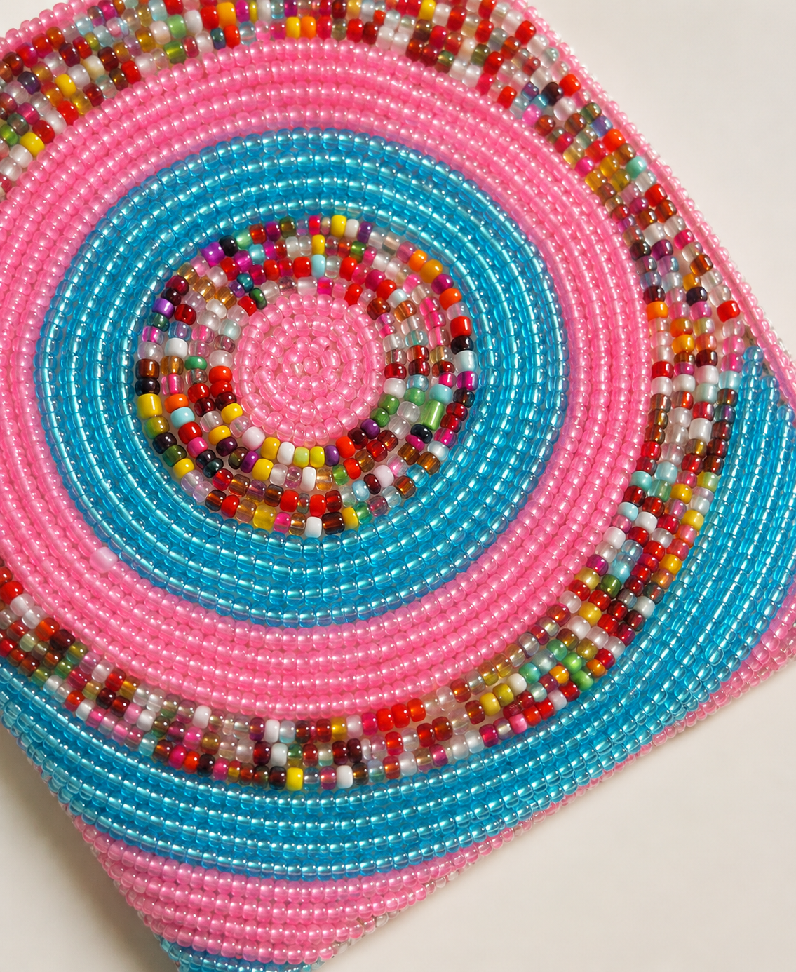 Kalea mini pink and turquoise beaded pouch with multicolour concentric circle pattern